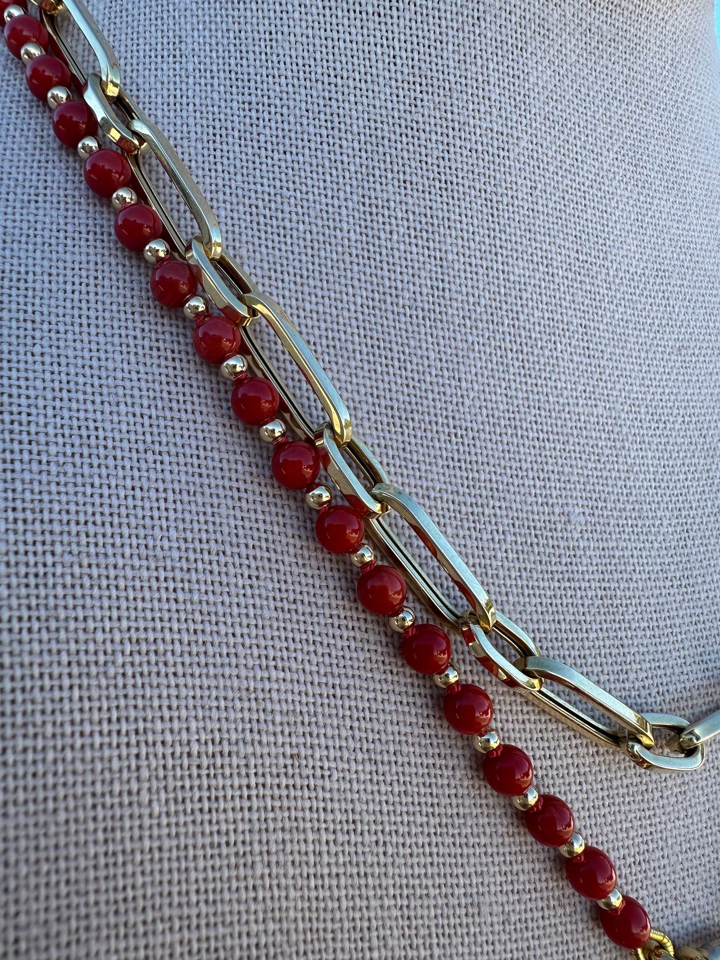 Detail of coral bead surface texture and gold-plated clasp connection.