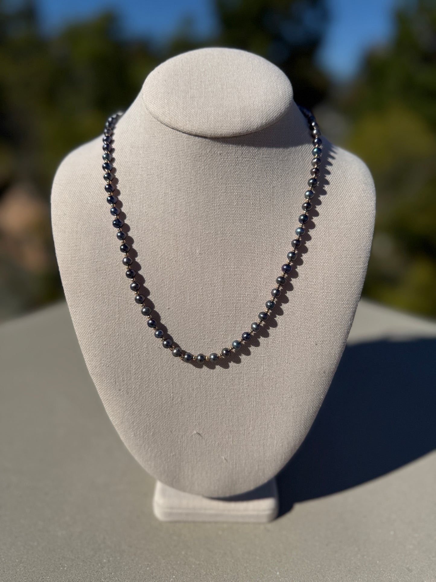 Black freshwater pearl necklace, hand-knotted with gold-plated beads and clasp, 21.5 inches long.