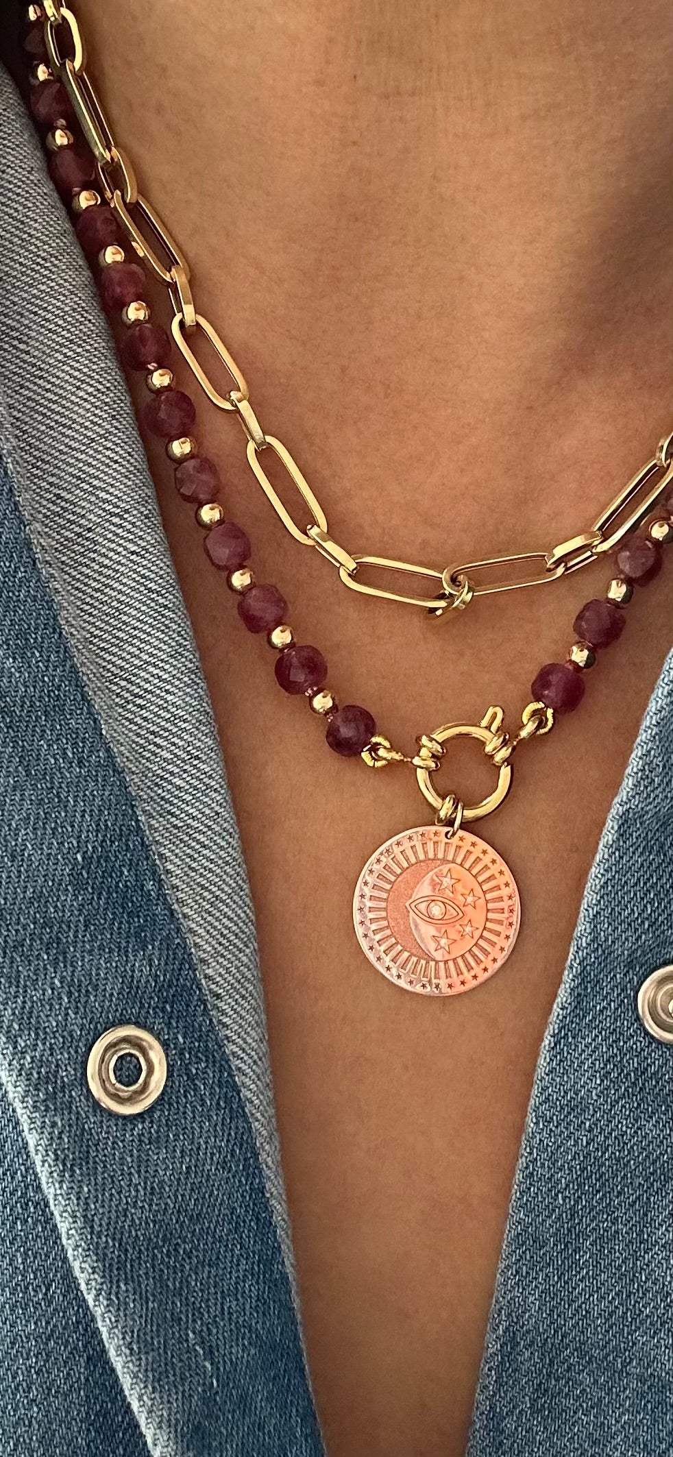 Person wearing ruby beaded necklace layered with gold chain and charm, 18.5-inch strand length.