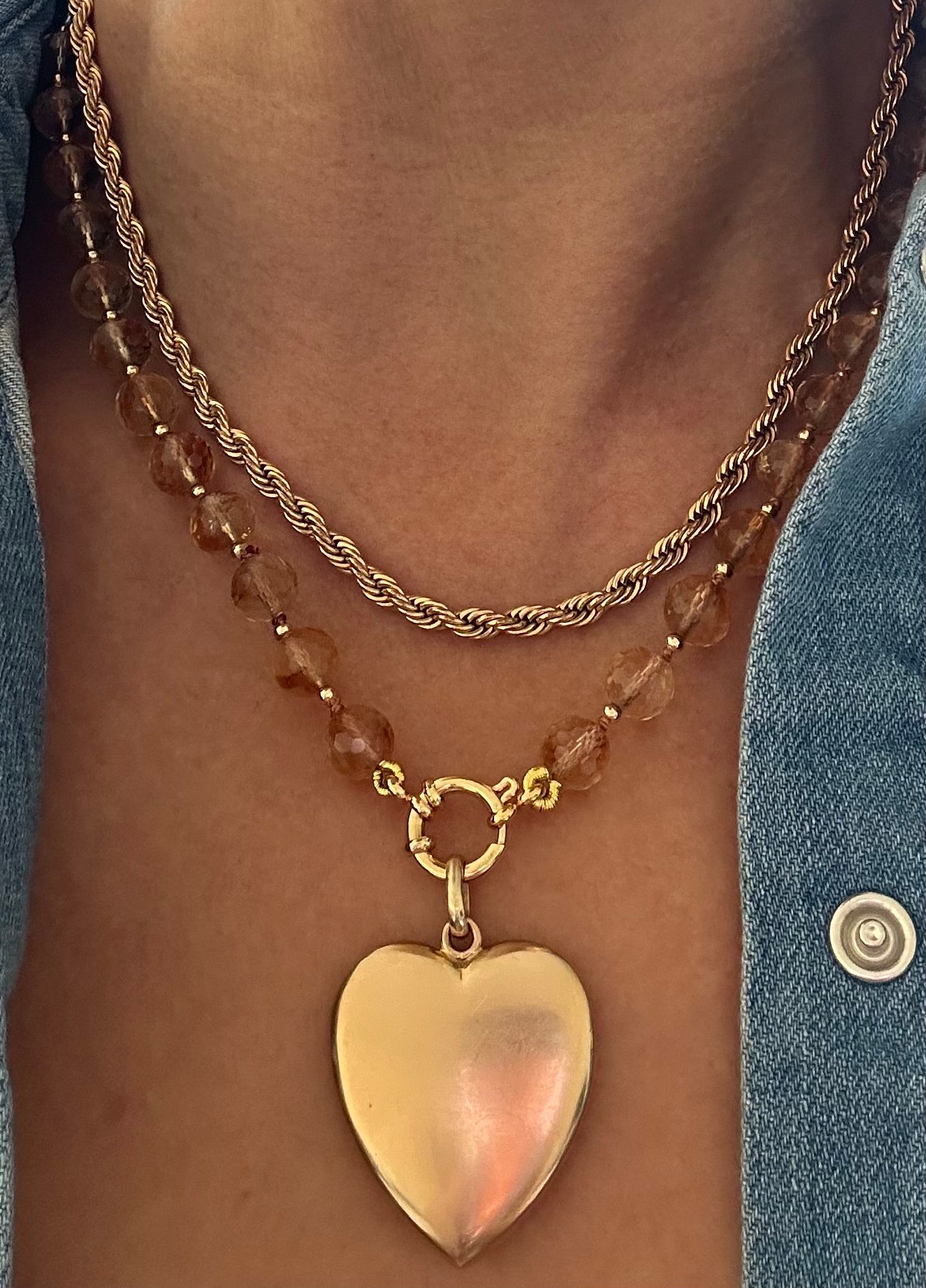 Person wearing citrine beaded necklace layered with gold chain and heart charm, 18.5-inch strand length.