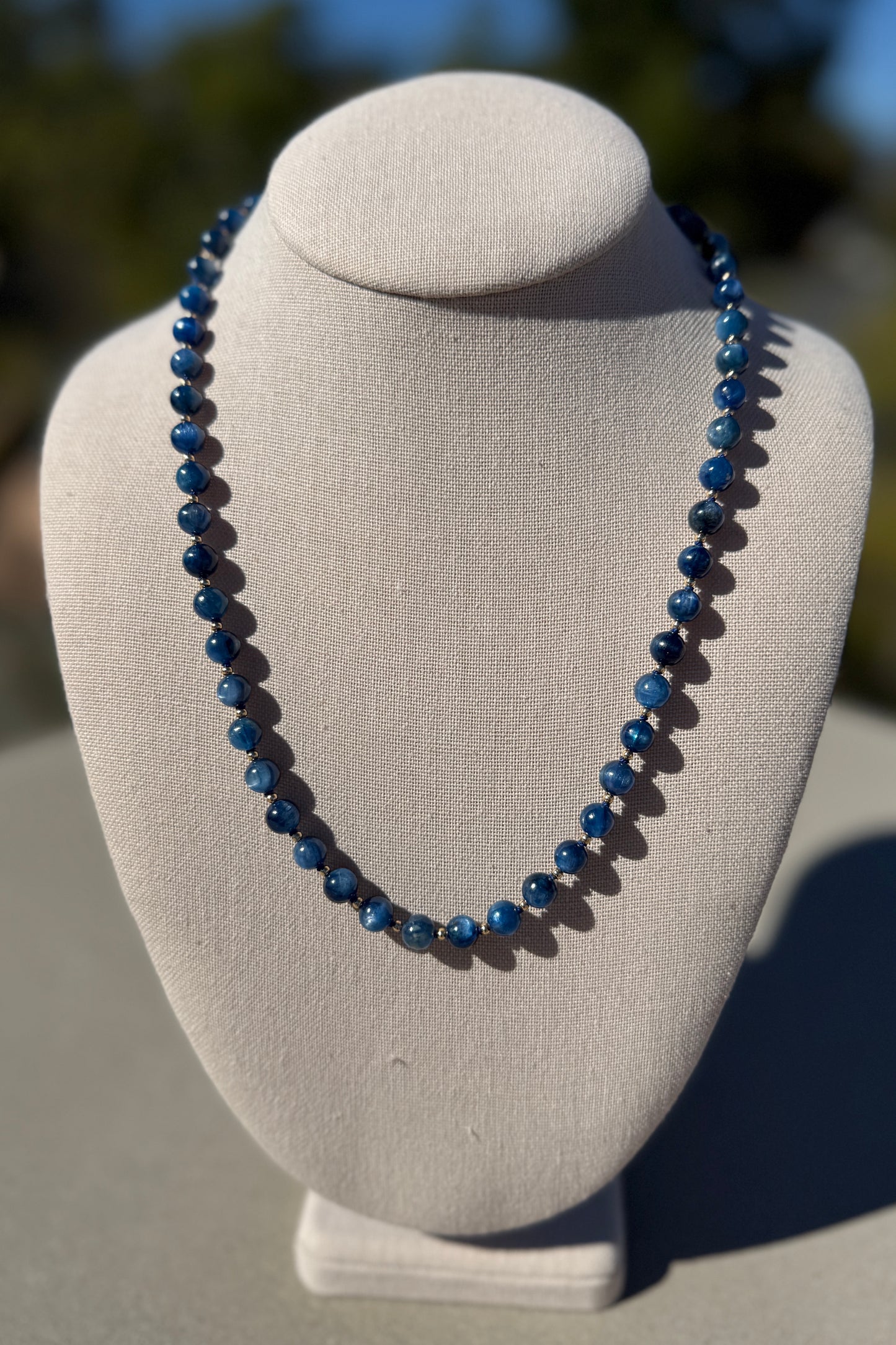 Kyanite beaded necklace, hand-knotted with gold-plated clasp, 21 inches long.
