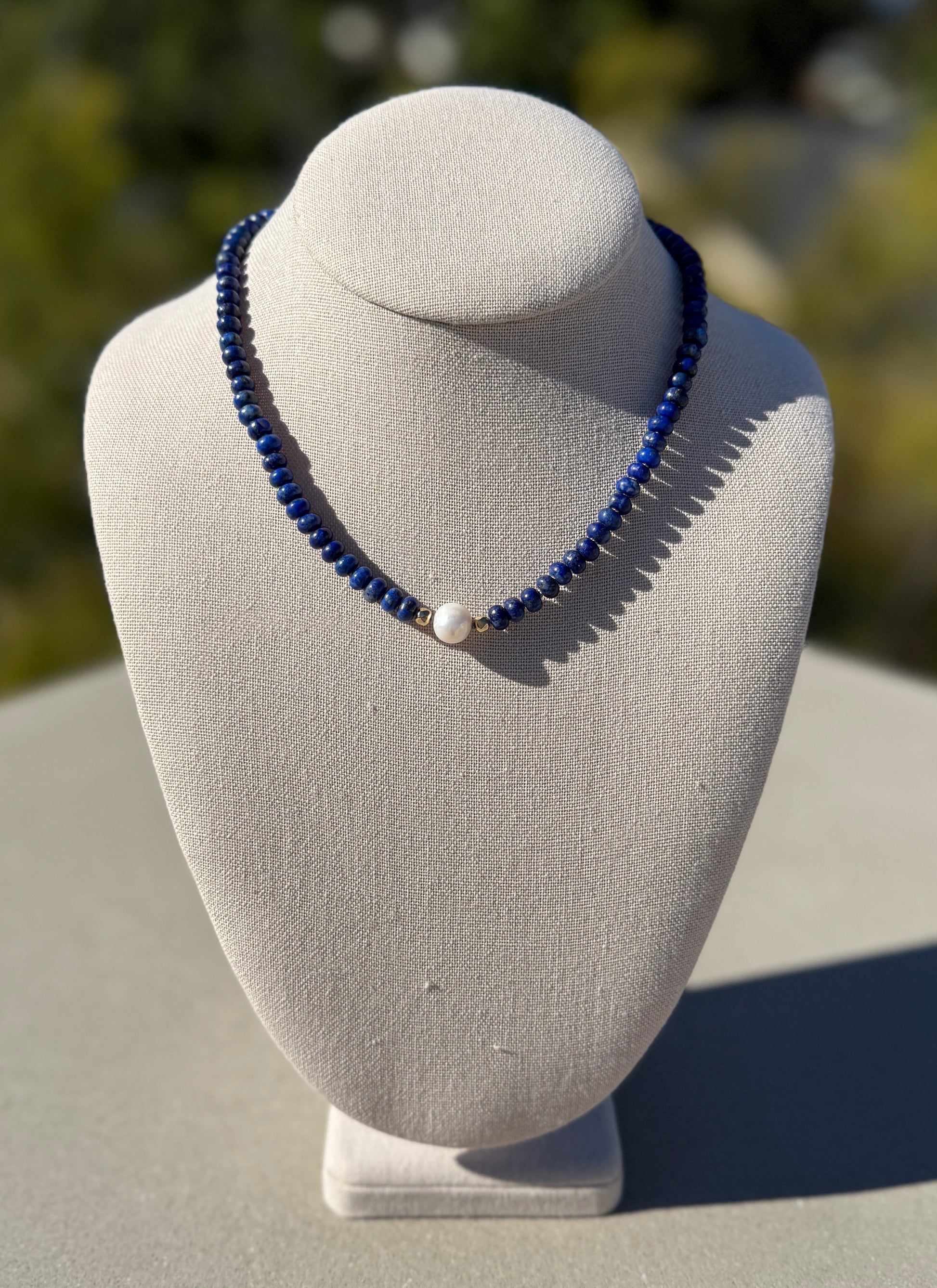 Lapis lazuli and freshwater pearl necklace, hand-knotted with gold-plated clasp, 20 inches long.