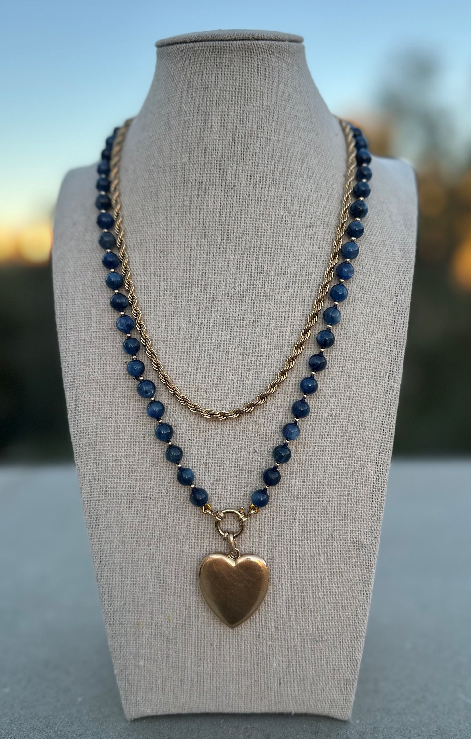Kyanite beaded necklace shown with separate gold chain and charm for styling, charm and chain not included.