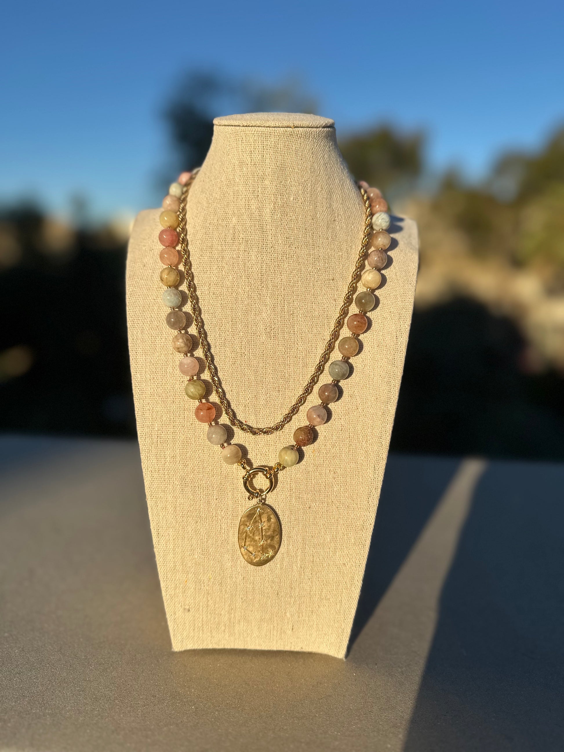 Multicolor beryl morganite necklace shown with separate gold chain and charm for styling, charm and chain not included.