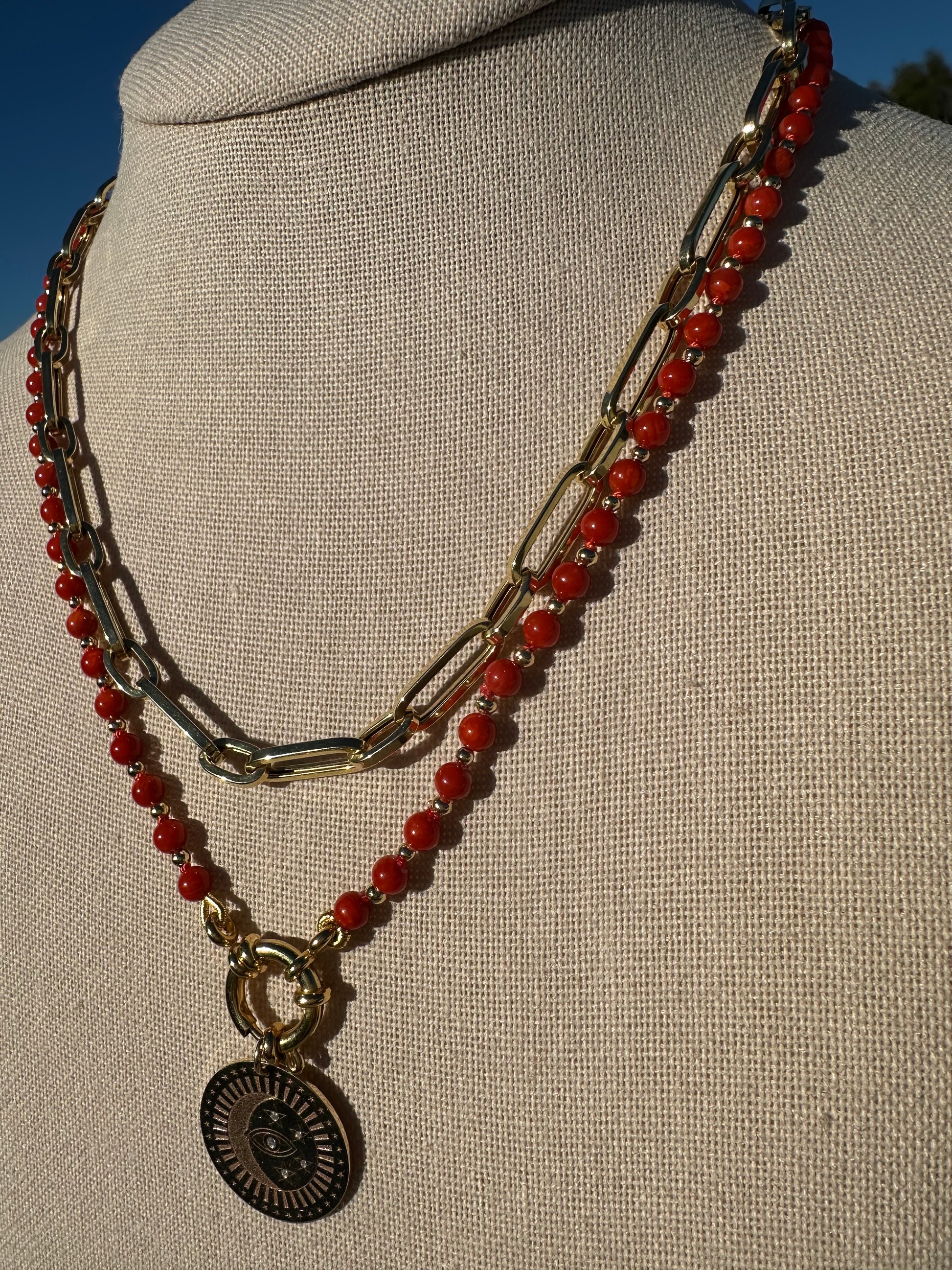 Close-up of coral beads showing knot spacing and gold-plated clasp detail.