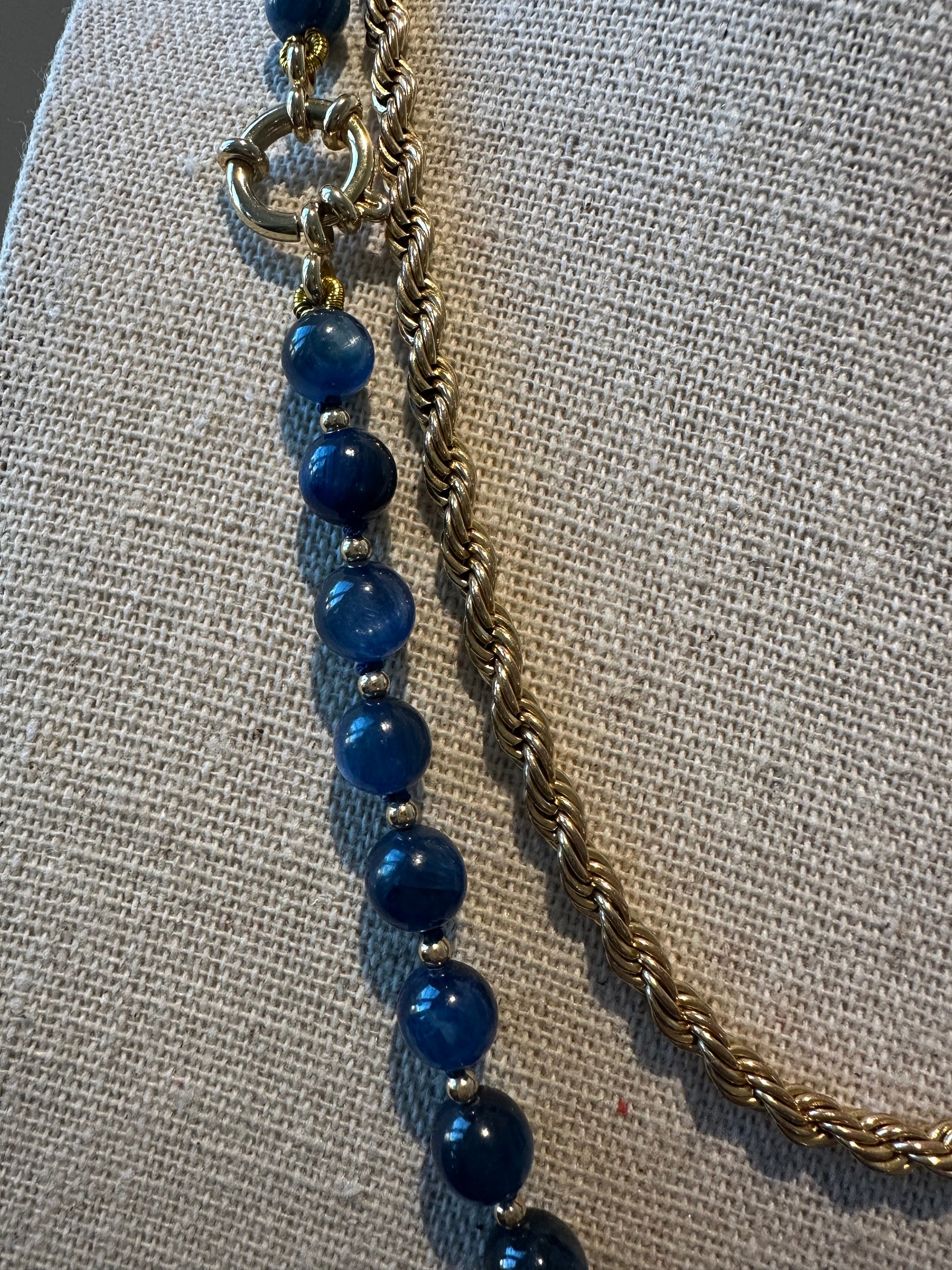 Close-up of kyanite beads and gold-plated clasp showing knot spacing and connector detail.