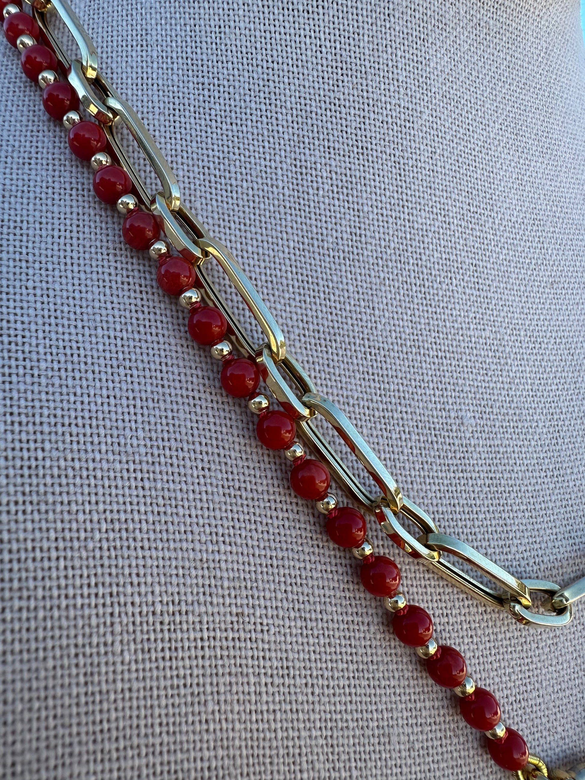 Detail of coral bead surface texture and gold-plated clasp connection.