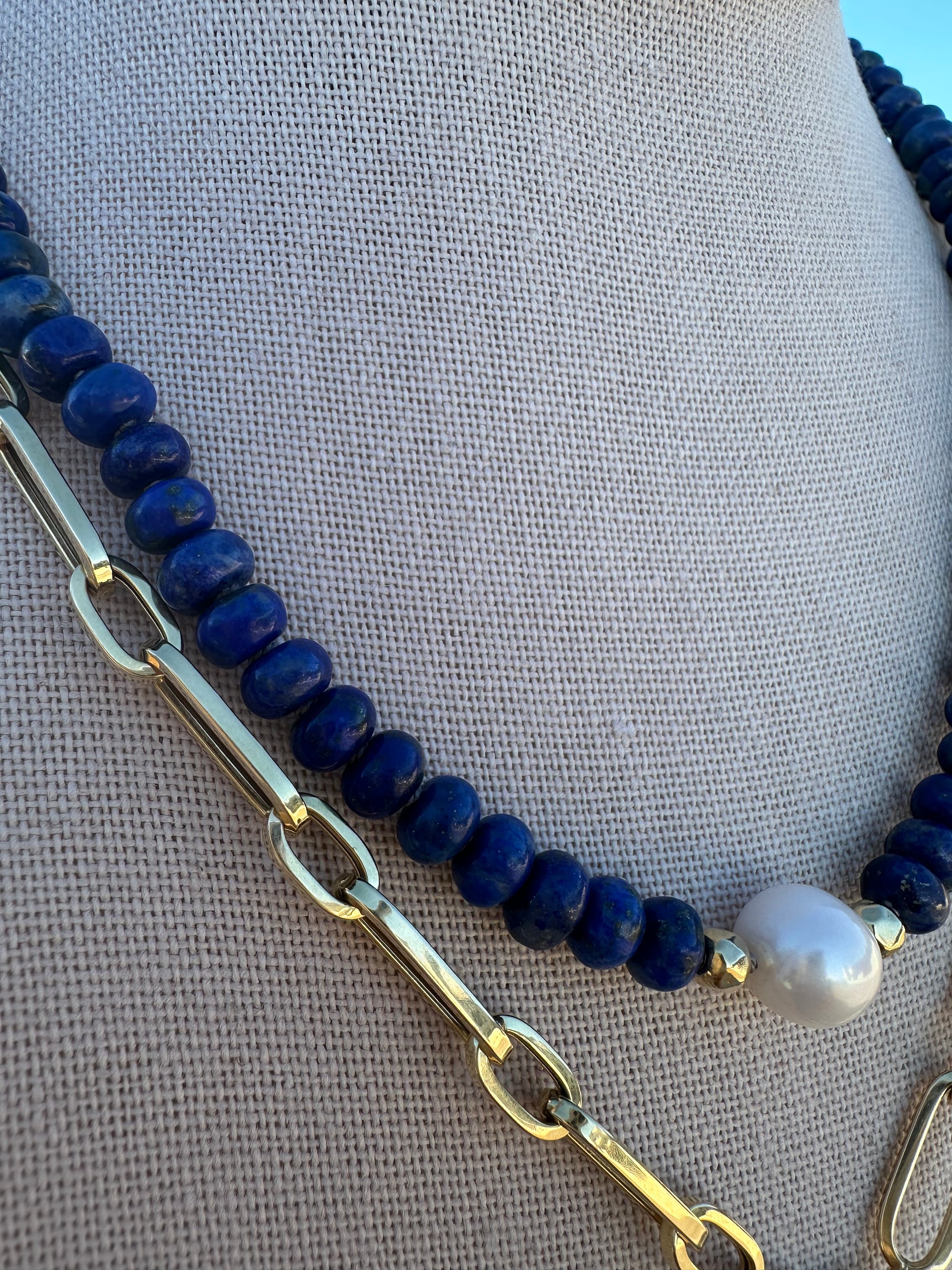 Detailed view of lapis lazuli bead texture and pearl surface on hand-knotted strand.