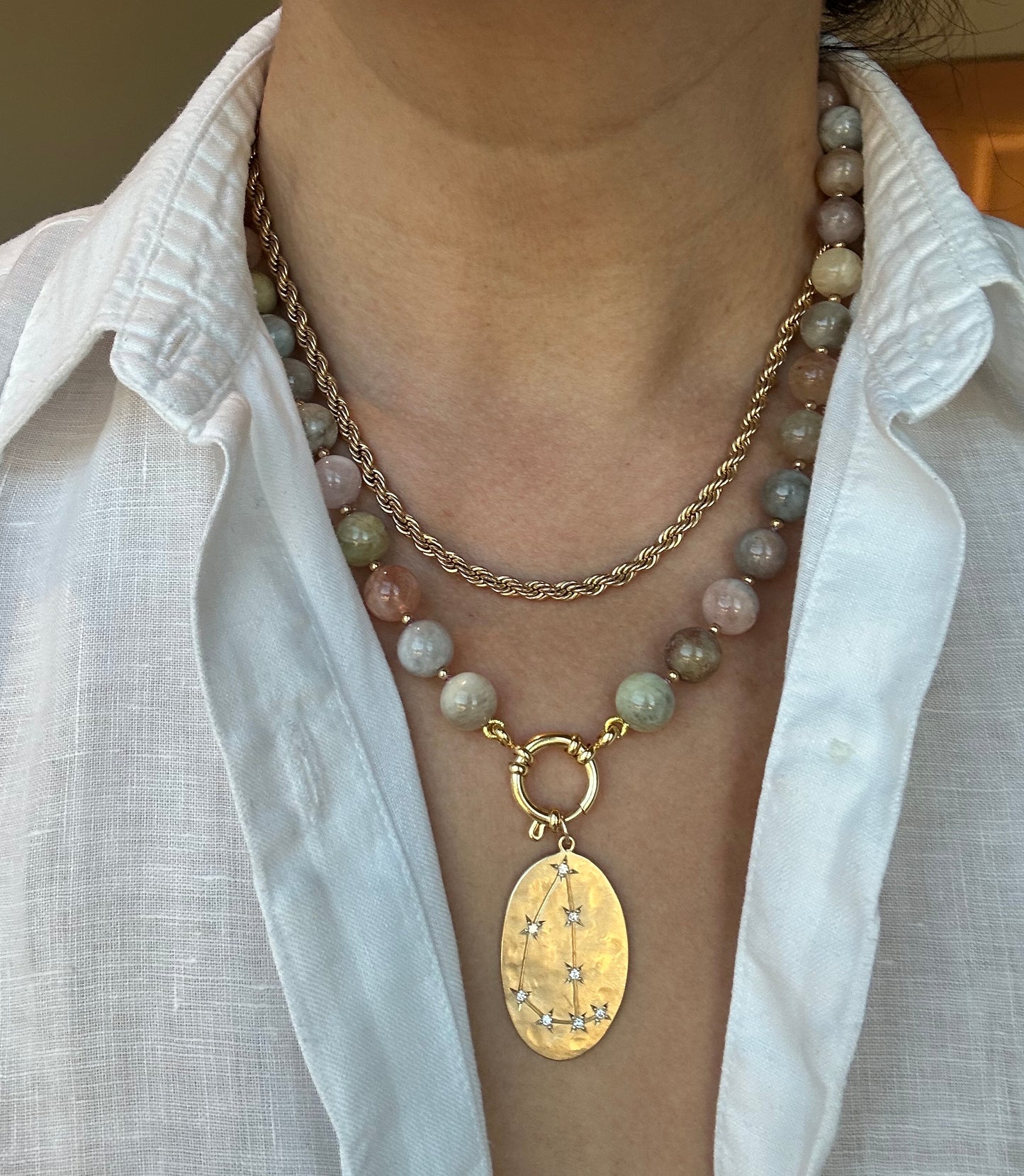 Person wearing multicolor beryl morganite necklace around neck, 20-inch strand length.