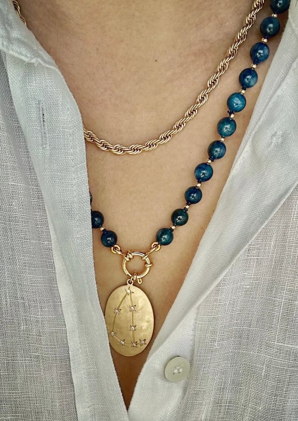 Person wearing kyanite beaded necklace around neck, 21-inch strand length.