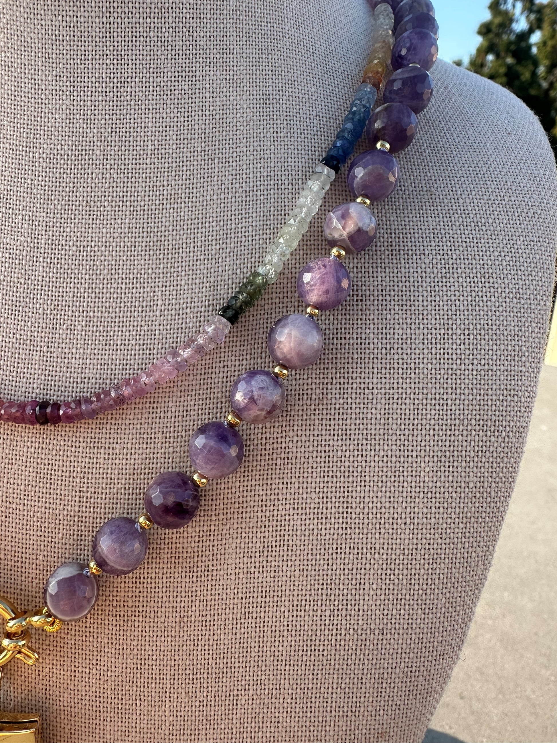 Close-up of faceted amethyst beads with gold accent beads between knots