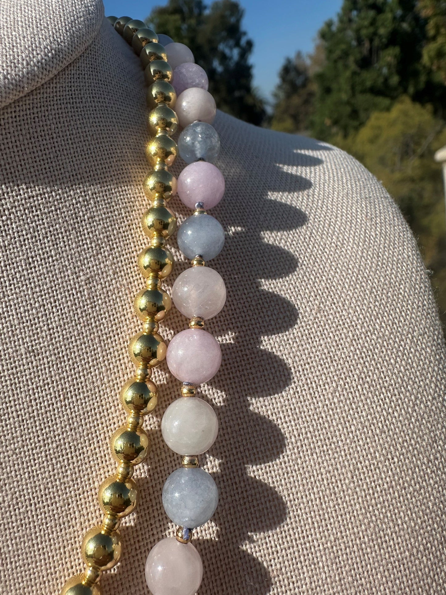 Detailed view of morganite bead color variation and gold accents