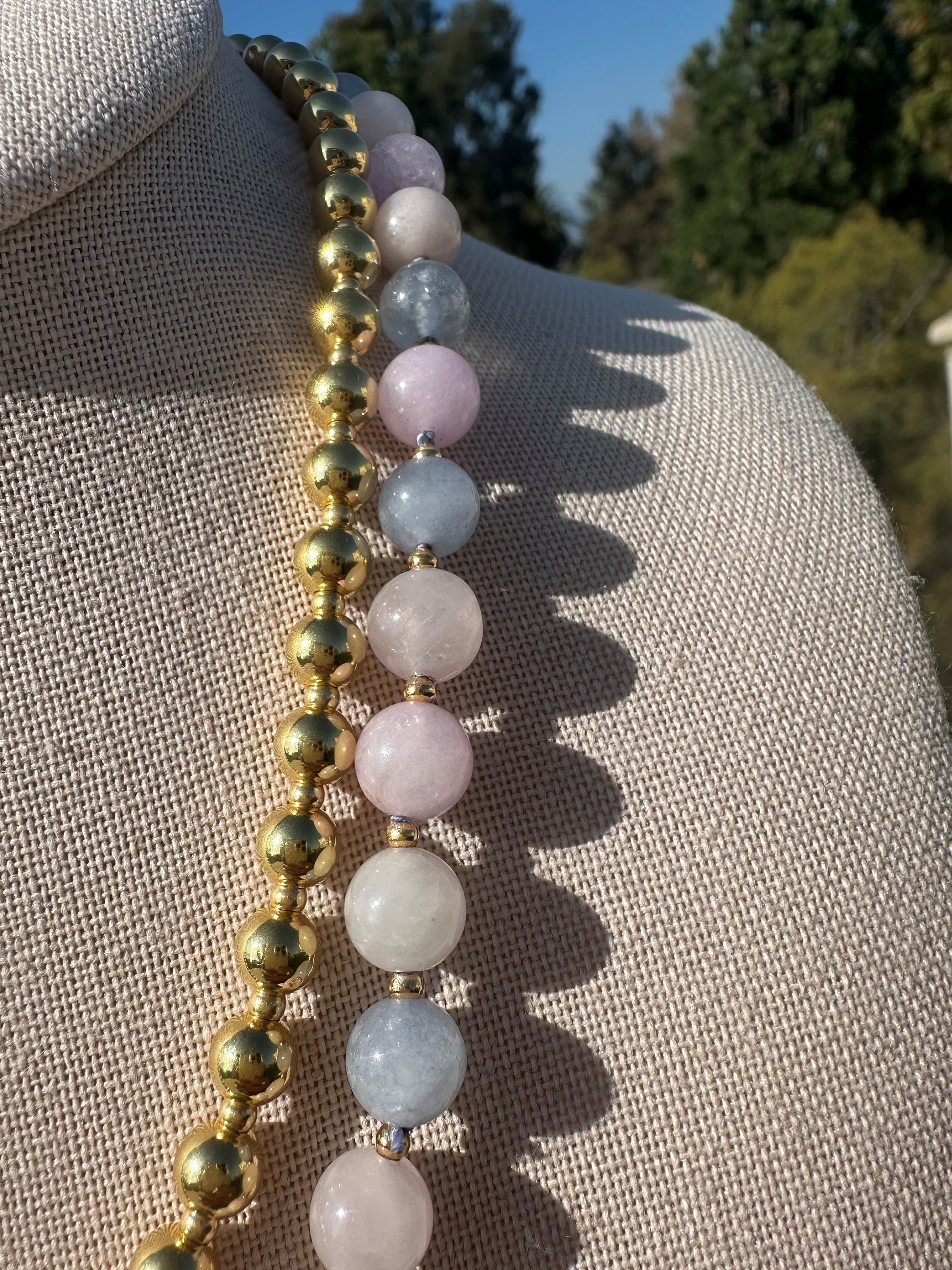 Detailed view of morganite bead color variation and gold accents