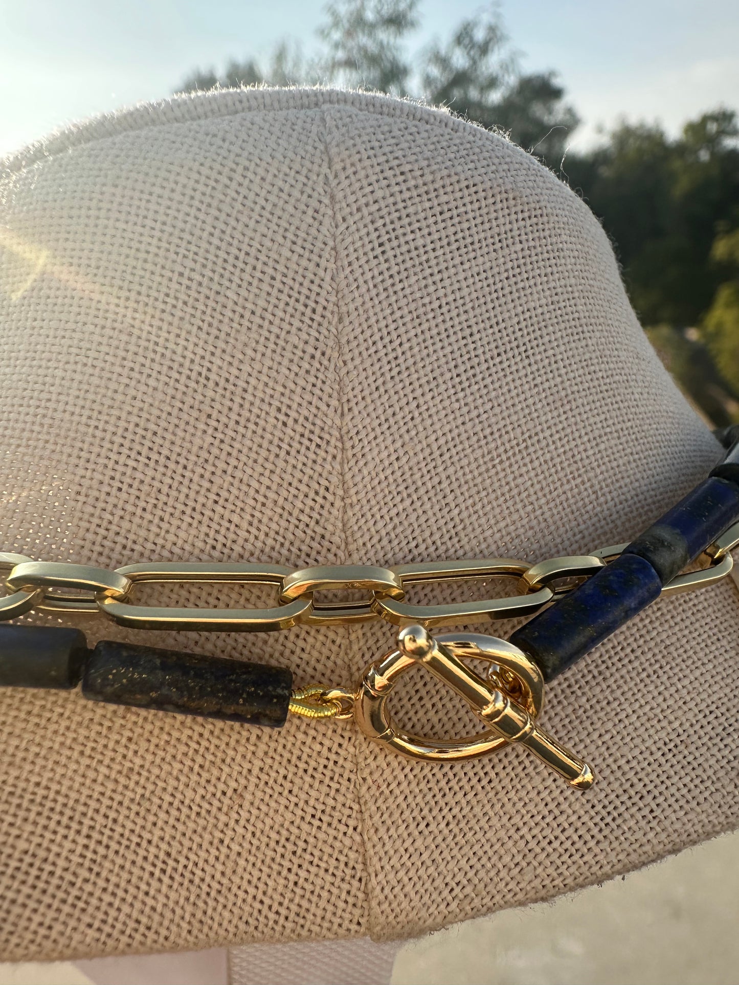 Close-up of lapis tube beads, coral accent, and gold toggle detail